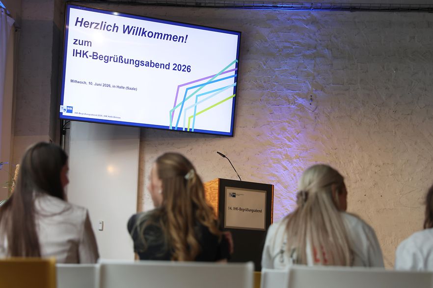 Blick zur B&uuml;hne mit Veranstaltungsthema im Hintergrund