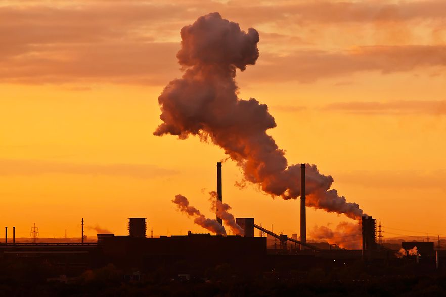 Industrielandschaft im Ruhrgebiet mit rauchenden Fabrikschloten.