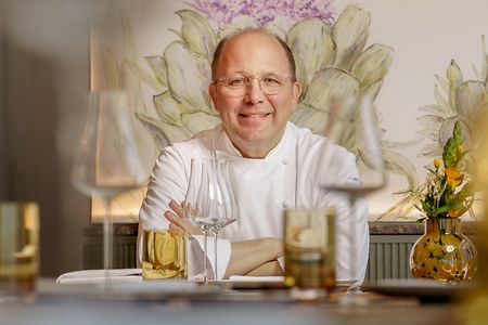 Dirk Luther sitzt am gedeckten Tisch.