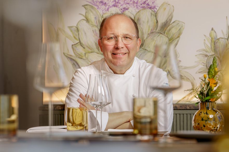 Dirk Luther sitzt am gedeckten Tisch.