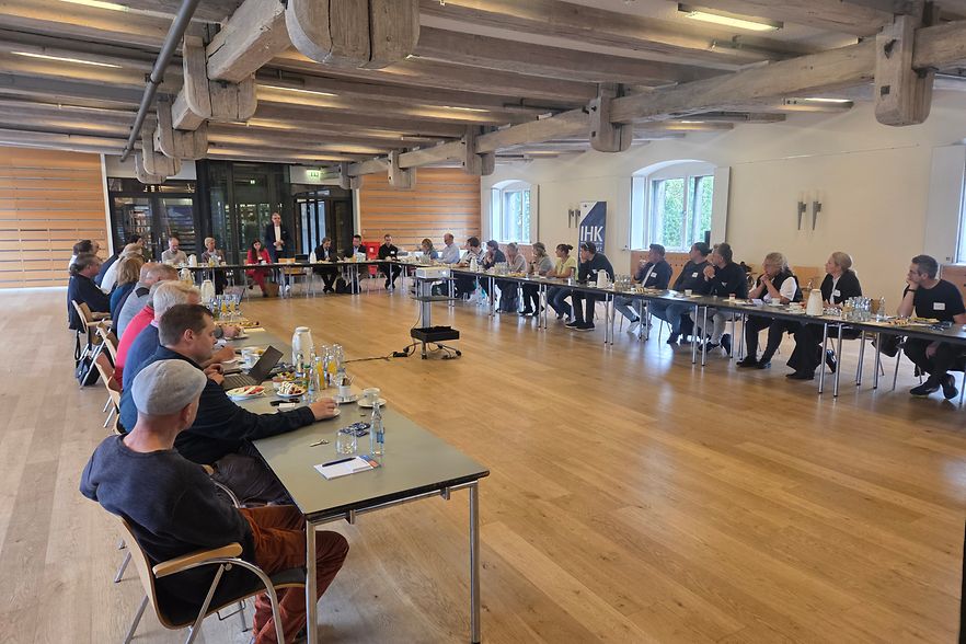 viele Personen sitzend an einem Tisch in U-Form
