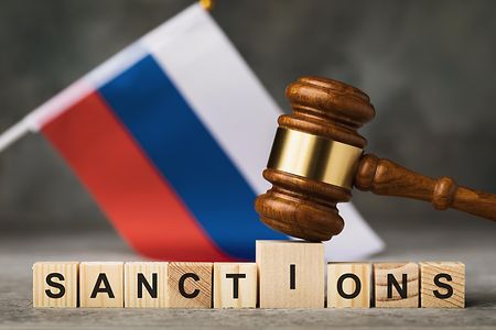 Die russische Flagge mit dem Schriftzug Sanktionen in Englisch 