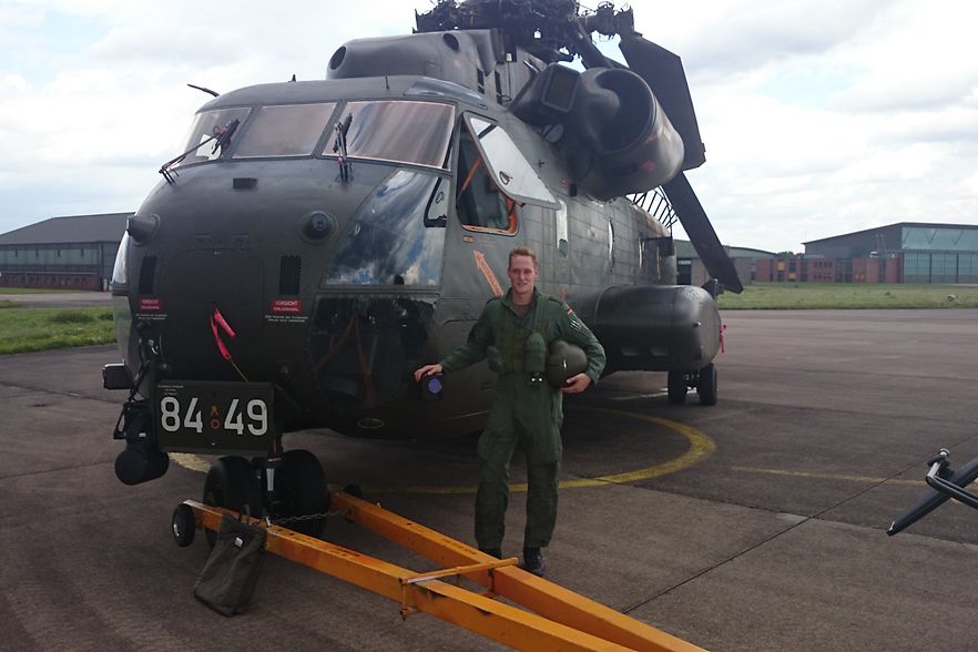 Patrick Kammann in Uniform vor einem Milit&auml;rhubschrauber. 