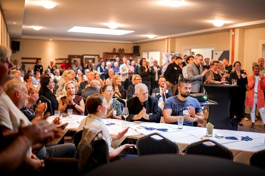 viele Personen sitzend in einem Konferenzraum