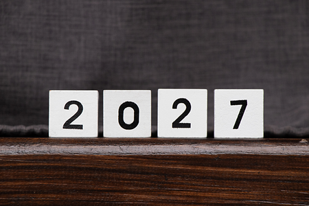 W&uuml;rfel auf einem Holztisch mit 2027 bedruckt